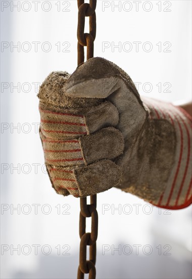 Close up of gloved hand holding chain.