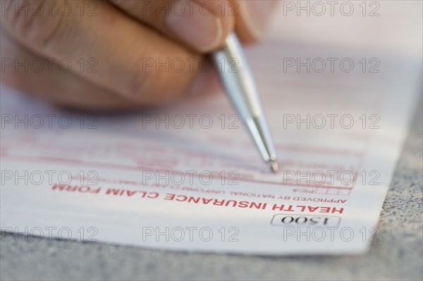 Man filling out health insurance claim form.