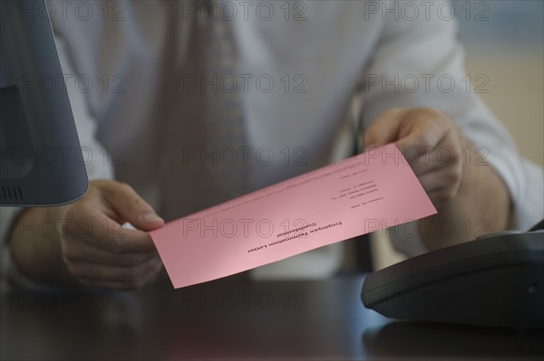 Man holding pink slip.