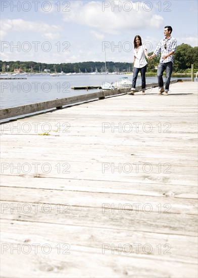 Couple holding hands and walking on dock. Date : 2008