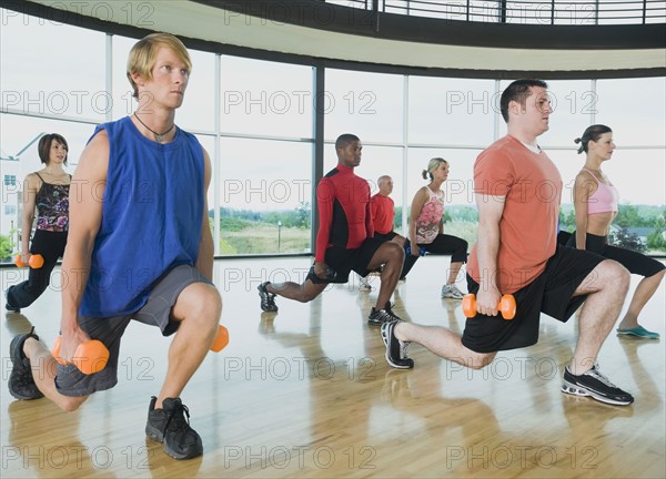 Fitness class doing lunges with dumbbells. Date : 2008