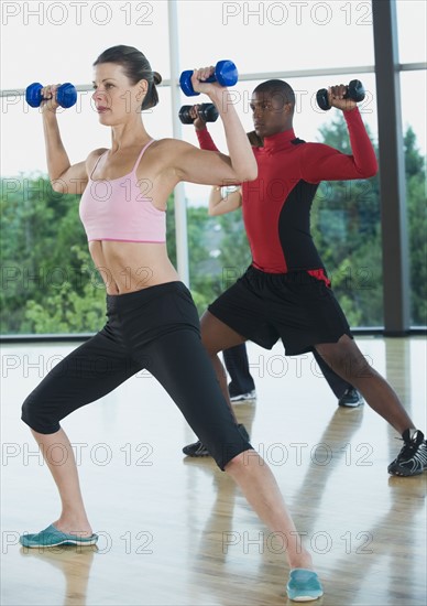 Fitness class doing shoulder presses with dumbbells. Date : 2008