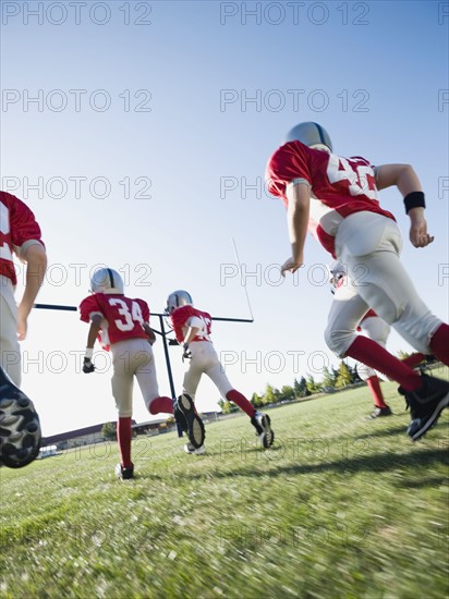 Football players running on field. Date: 2008