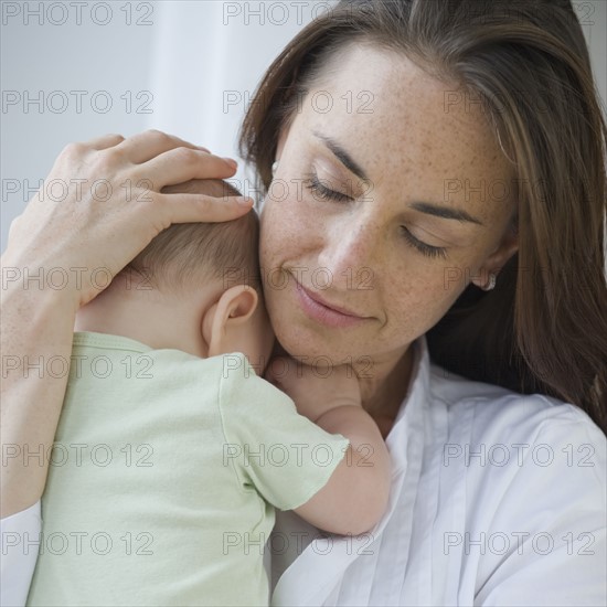 Mother holding baby son.