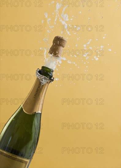 Cork exploding from champagne bottle.