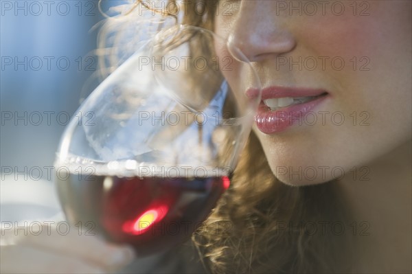 Close up of woman smelling red wine.