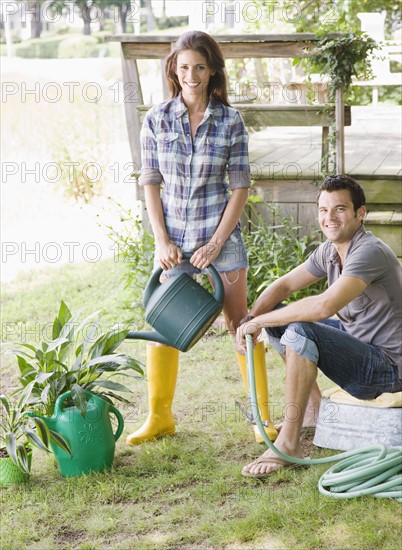 Couple watering plants in backyard. Date : 2008