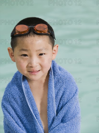 Boy wrapped in towel posing in front of swimming pool. Date : 2008