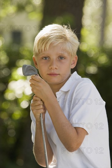 Portrait of boy with golf club. Date: 2008