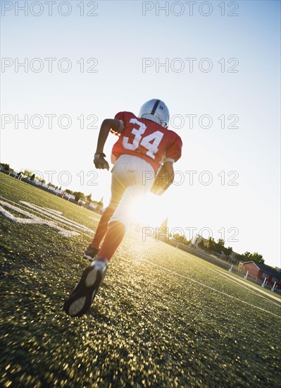 Football player running on field with football. Date : 2008