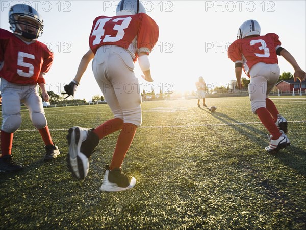 Football players running on field. Date : 2008