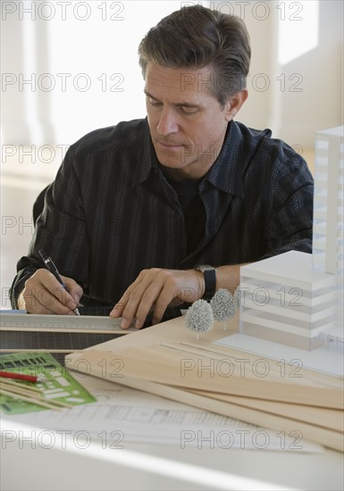Architect working on building model.