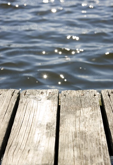 Close up of dock and sun reflecting on lake. Date: 2008