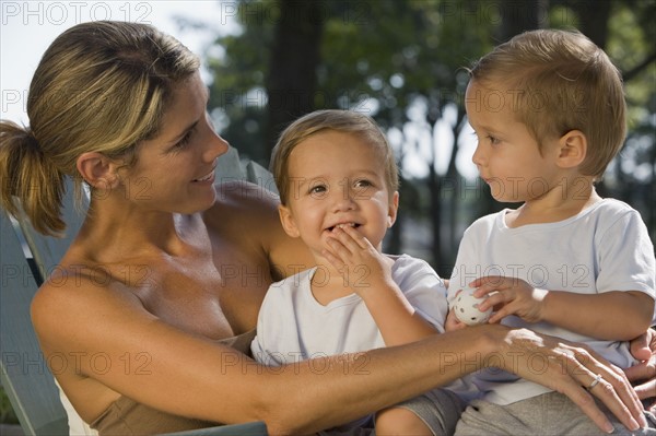 Mother holding twin toddler sons. Date : 2008