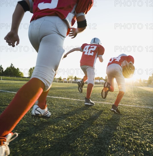 Football players running on field. Date: 2008