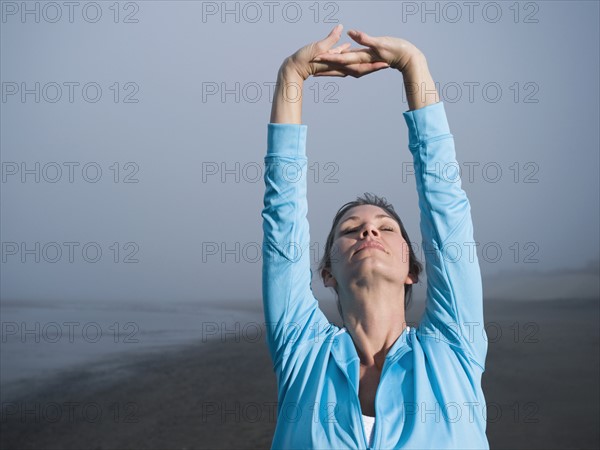 Woman stretching on foggy beach. Date : 2008