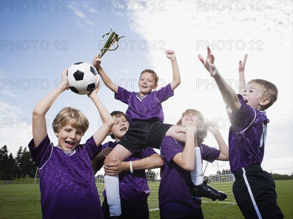 Boys soccer team celebrating with trophy. Date : 2008