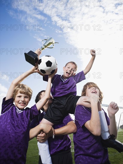 Boys soccer team celebrating with trophy. Date : 2008