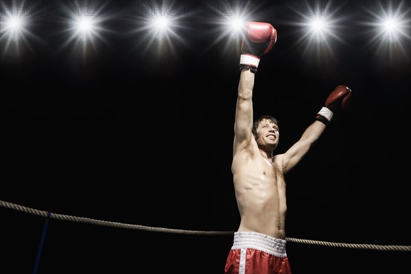 Boxer standing in boxing ring with gloves raised. Date: 2008