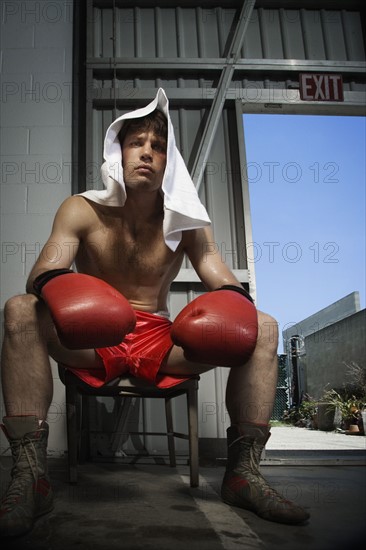 Portrait of boxer sitting on stool near doorway. Date: 2008