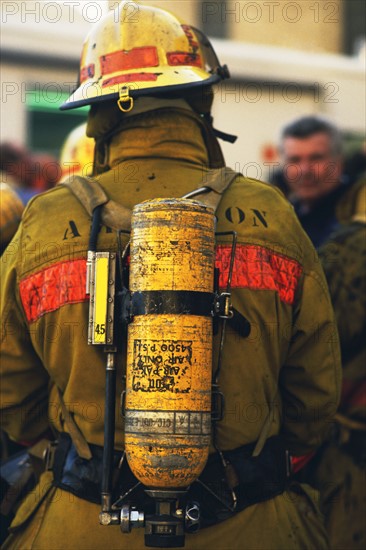Rear view of fireman wearing oxygen tank. Date: 2008