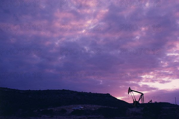 Oil rig in distance under sunset sky. Date : 2008