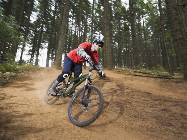 Mountain biker speeding down forest trail. Date : 2008