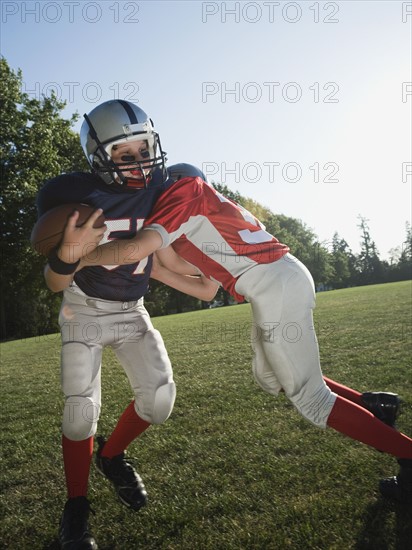 Football player tackling opponent. Date: 2008
