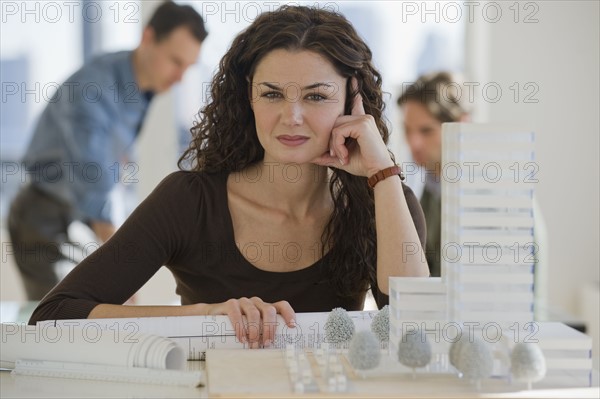 Portrait of architect with blueprints and building model.