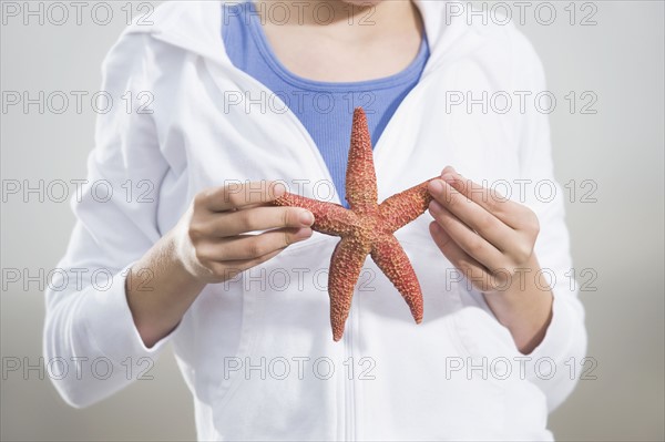 Portrait of girl holding starfish. Date : 2008