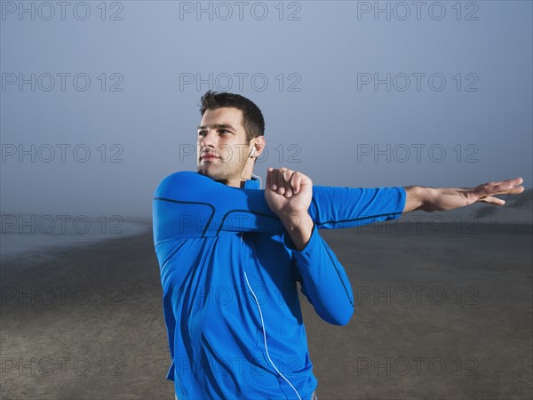 Man stretching on beach. Date : 2008