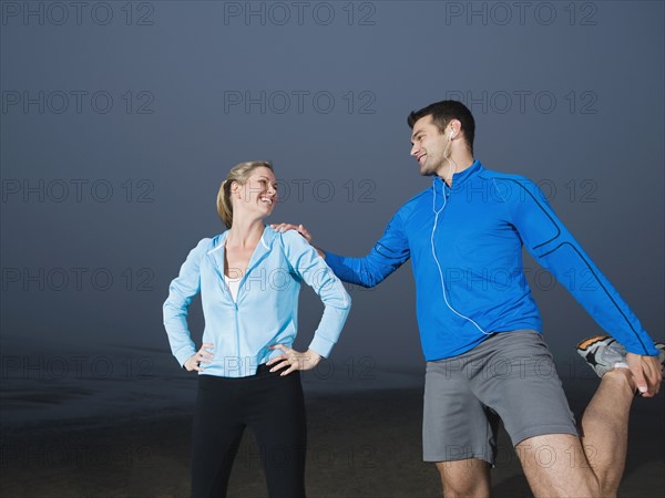 Couple stretching on beach. Date : 2008