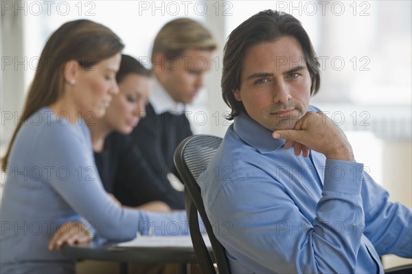 Portrait of businessman with business people in background.