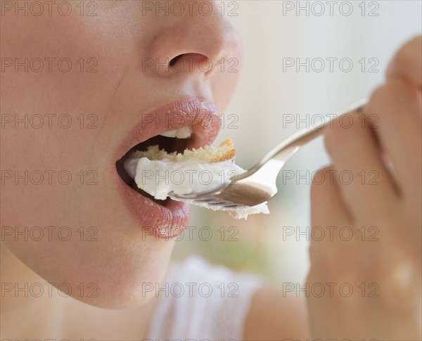 Close up of woman eating cake.