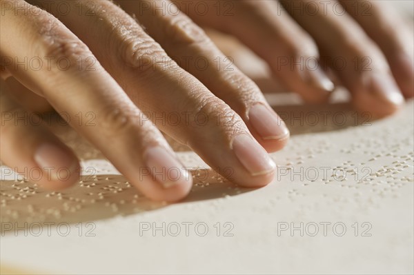 Close up of hand reading braille.