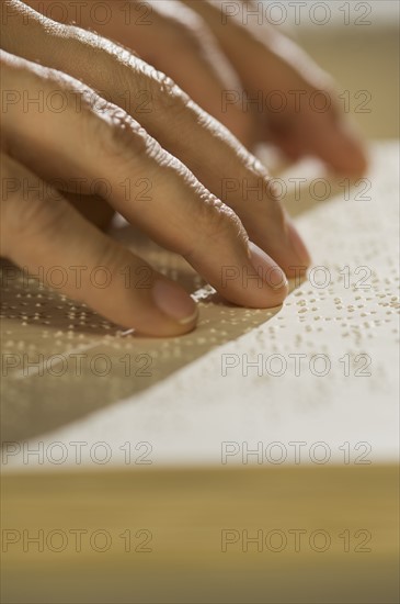 Close up of hand reading braille.