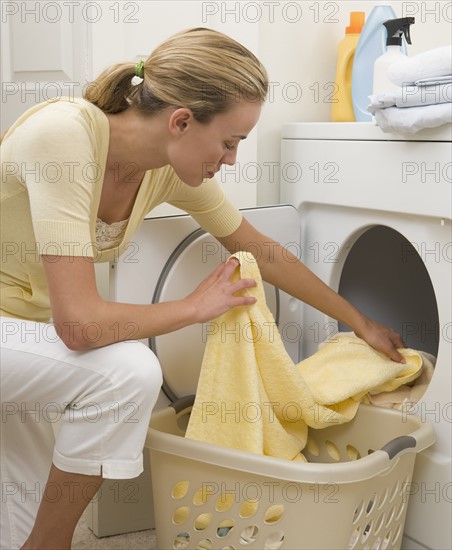 Woman removing towels from dryer.