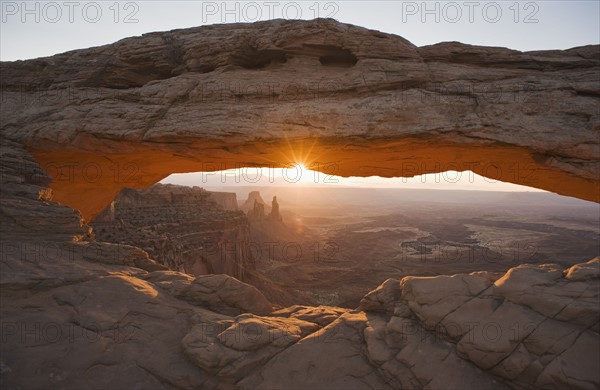 Sun shining behind Mesa Arch, Canyonlands National Park, Utah.