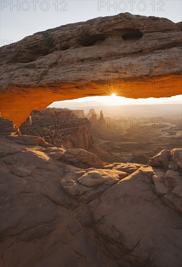 Sun shining behind Mesa Arch, Canyonlands National Park, Utah.