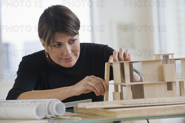 Architect constructing building model.