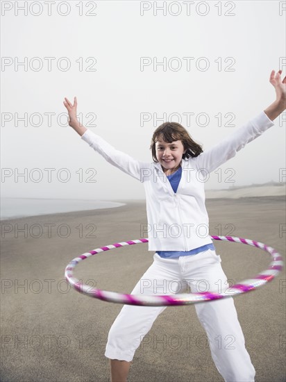 Portrait of girl with hula hoop on beach. Date : 2008
