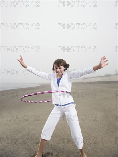 Portrait of girl with hula hoop on beach. Date: 2008