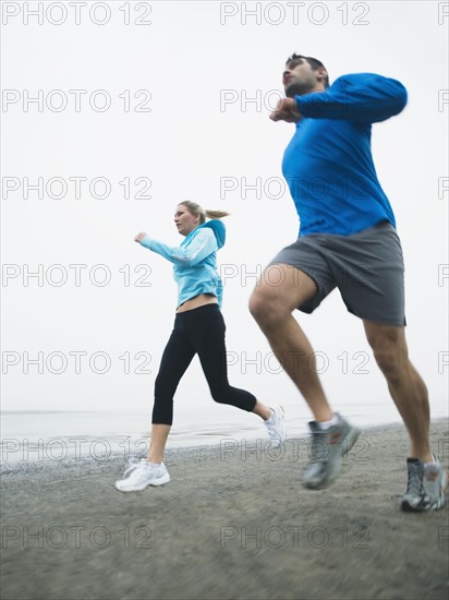 Couple jogging on beach. Date: 2008