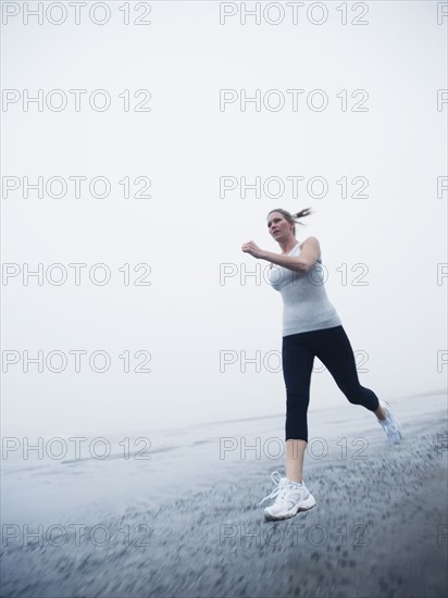 Woman jogging on foggy beach. Date: 2008