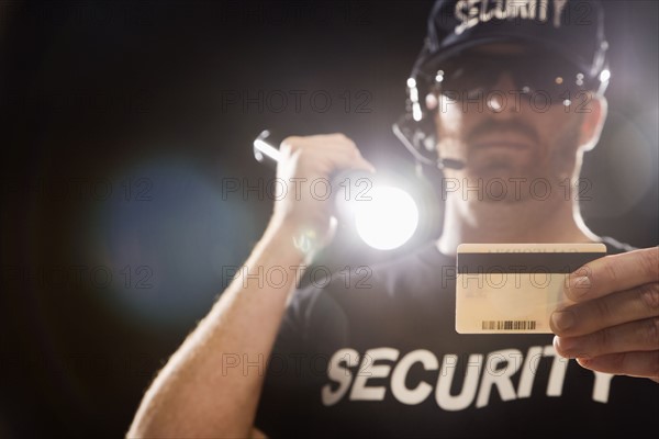 Bouncer checking identification with flashlight. Date : 2008