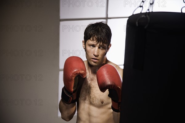 Boxer training with punching bag. Date : 2008