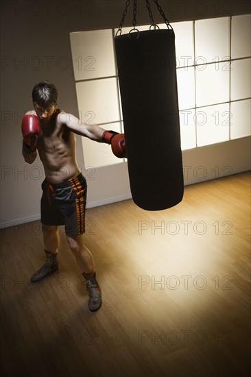 Boxer training with punching bag. Date : 2008