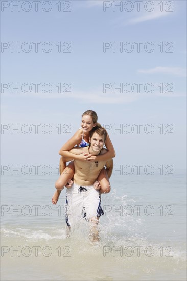 Couple splashing in ocean surf. Date: 2008