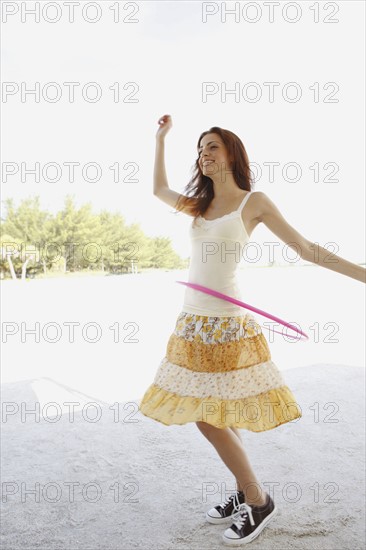 Woman on beach with hula hoop. Date : 2008