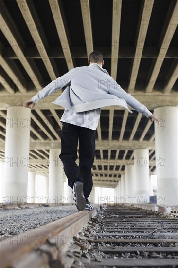 Man balancing on railroad tracks. Date : 2008